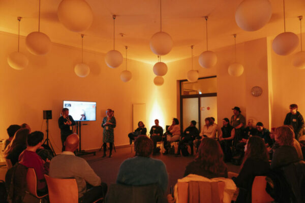 Workshop, People in a circle, 2 presenters and a sscreen