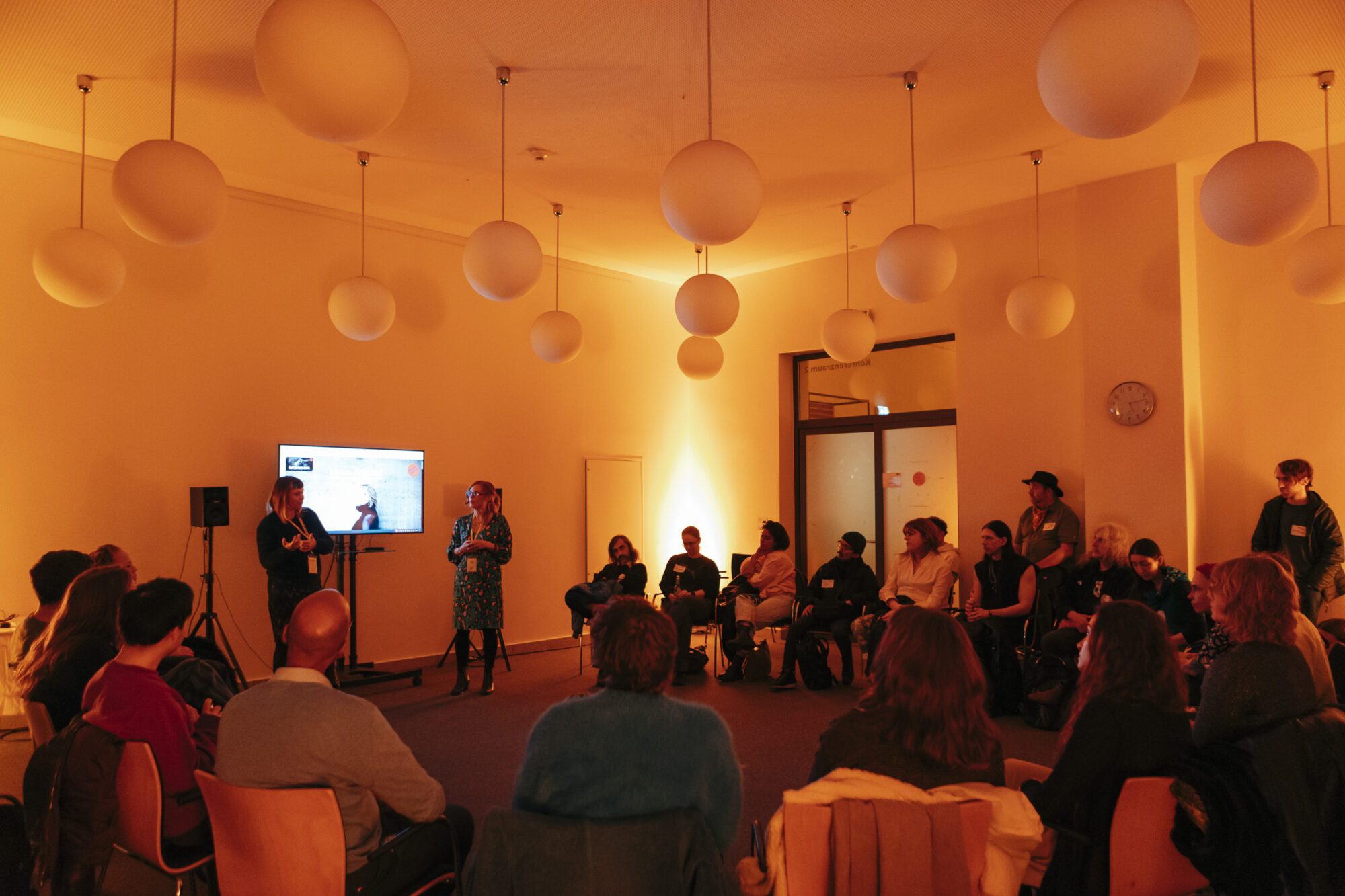 Workshop, People in a circle, 2 presenters and a sscreen